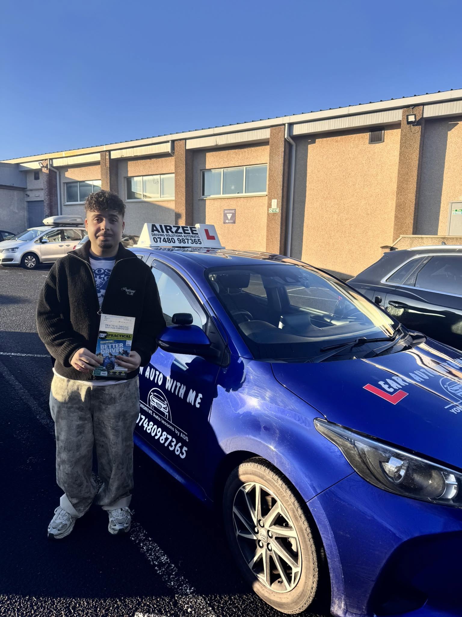 YorDrive learner celebrating with practical driving test pass certificate, blue training car